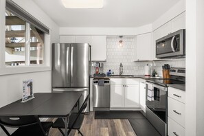 A modern kitchen with stainless steel appliances, a dishwasher, and a microwave.