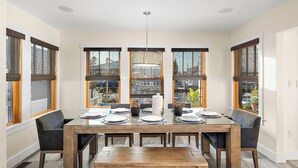 A dining area with a glass-top table, six chairs, and a bench. - Dock Access: Waterfront Ocean City Home Near Beach (Ocean City)