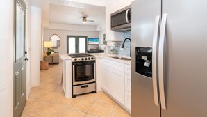 Een moderne keuken met een inbouwoven, een koelkast en een magnetron.