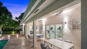 An outdoor patio area with a pool, dining table, and chairs. - BY THE SEA VACATION VILLAS 5 STAR AZUL 3/2 PRIVATE POOL WALK TO BEACH (Fort Lauderdale)