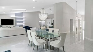 A modern kitchen with white cabinets, a large island, and a stainless steel sink. - BY THE SEA VACATION VILLAS 5 STAR AZUL 3/2 PRIVATE POOL WALK TO BEACH (Fort Lauderdale)