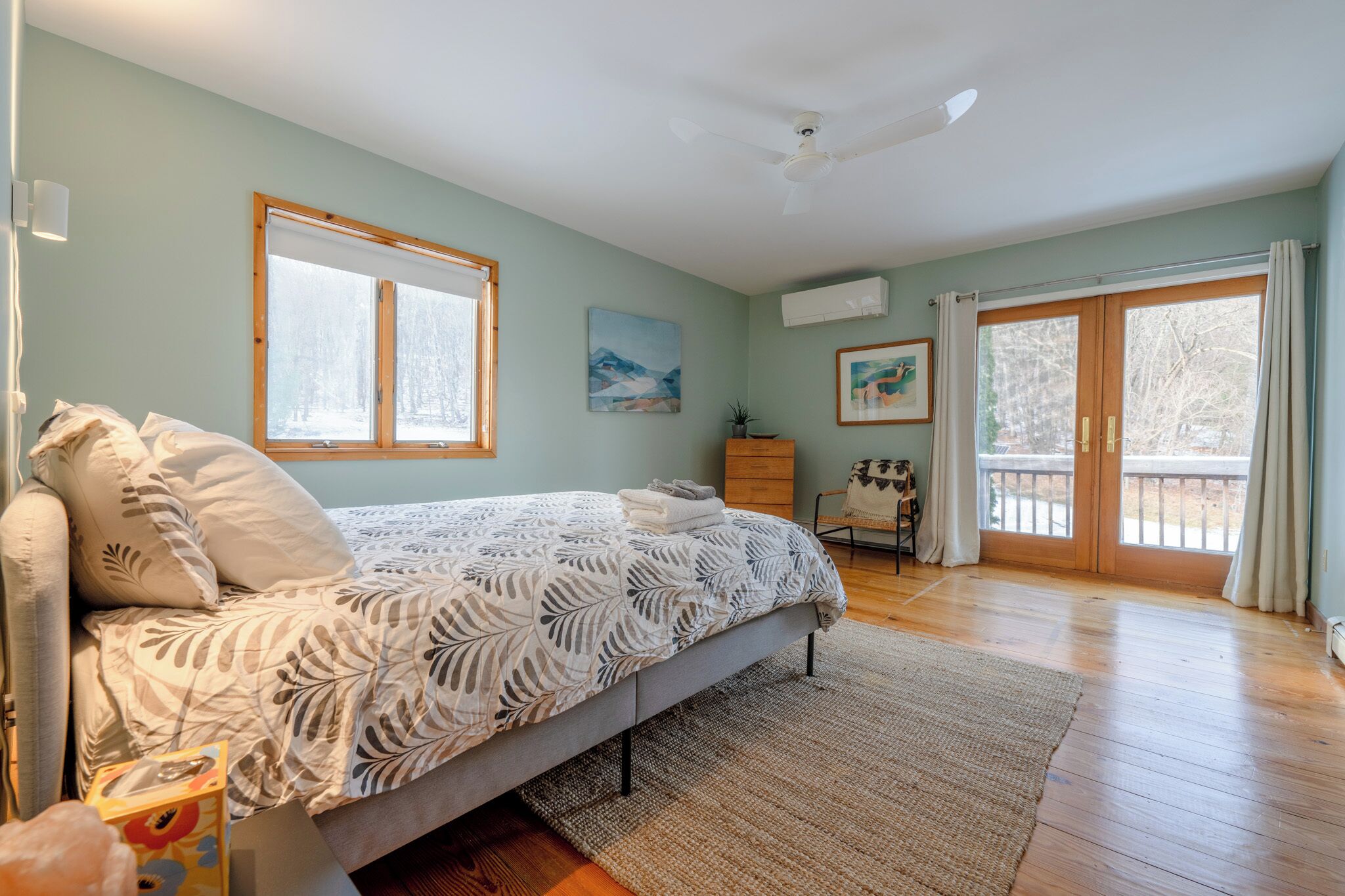 A bedroom with a bed, a dresser, a chair, and a window with curtains.