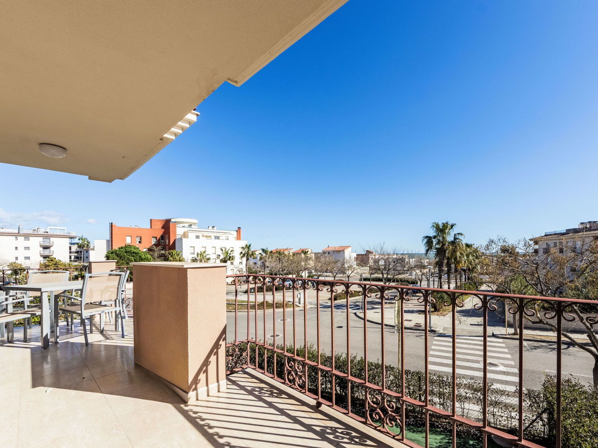 Ein Balkon mit Gartenmöbeln, Blick auf einen Kreisverkehr und Gebäude im Hintergrund.