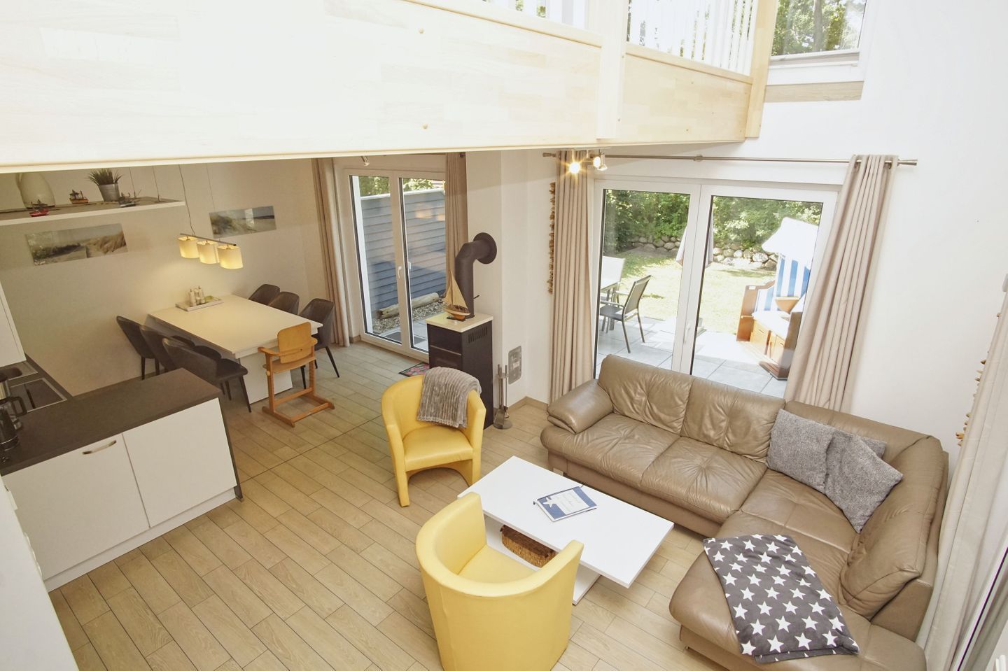 A modern interior with a dining area, sofa, and a kitchen.