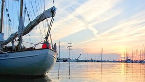 A boat docked at a marina with calm water and a sunset in the background. - Quiet location in Ostseebad Göhren, veranda, - Villa Möwe FeWo 03 - Villa Möwe (Göhren)