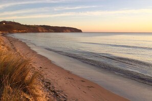 A beach with clear water, sandy shore, and a distant landmass. - Sealodge - beachfront home with ocean views, access to the pool and sauna - (Göhren)