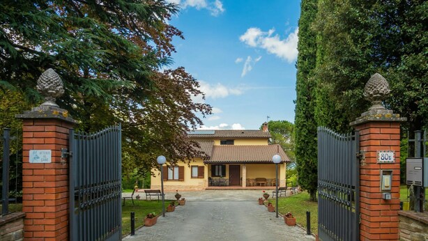 A gated entrance to a property with a paved driveway, a brick wall, and a sign indicating the property number 80B. - Wonderful private villa for 7 guests with WIFI, private pool, TV, terrace and pets allowed (Anghiari)