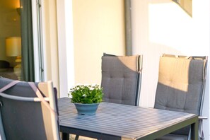 Une table avec une plante en pot et deux chaises.