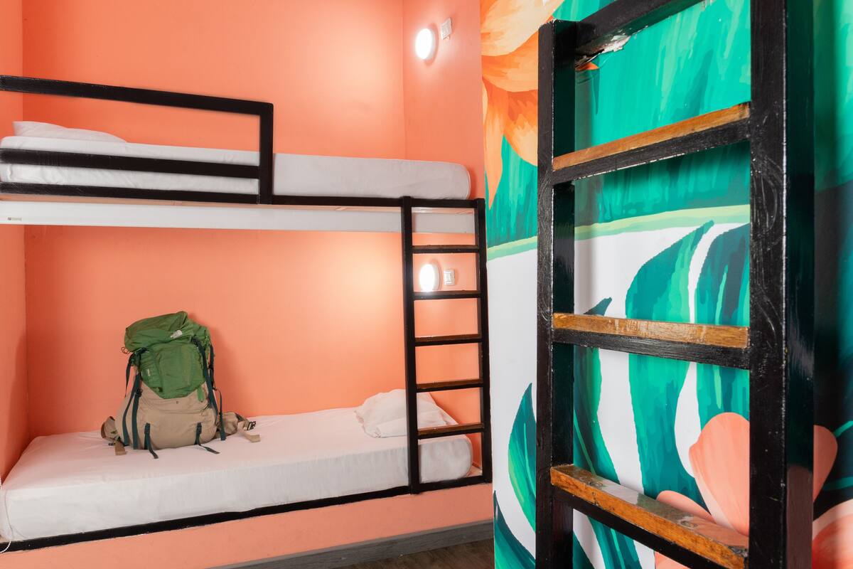 A bunk bed room with a green backpack on the lower bunk.