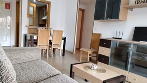 Una sala de estar moderna con un sofá, una mesa de centro y un comedor con sillas y una mesa.