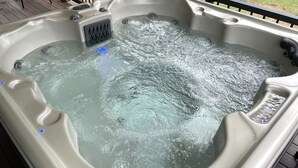 Un jacuzzi con múltiples chorros, un panel de control y un desagüe.