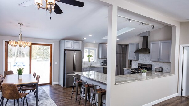 A modern kitchen with a central island, stainless steel appliances, and a dining area with a chandelier. - The Reserve at Plum Bottom in Egg Harbor! (Egg Harbor)