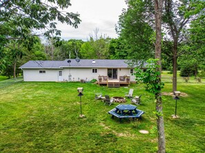 A single-story house with a deck, surrounded by a well-maintained lawn and trees. - The Reserve at Plum Bottom in Egg Harbor! (Egg Harbor)