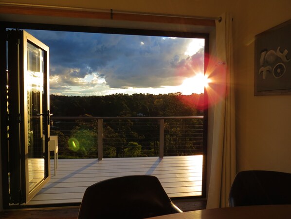 A balcony with a view of the sunset, a table, and chairs. - The Origami Apartment. Spacious, private, local views......close to town (Wentworth Falls)