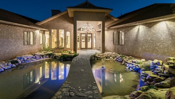 Une maison dotée d’une cour intérieure, d’une fontaine et d’une entrée bien éclairée.