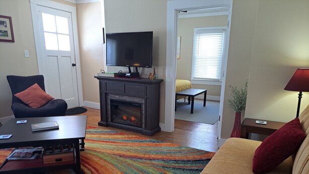 Una sala de estar con chimenea, televisor, sofá y mesa de centro.
