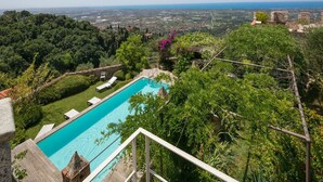A swimming pool with a view of a cityscape in the background. - Castle with pool and sea views for 6 People (Monteggiori)