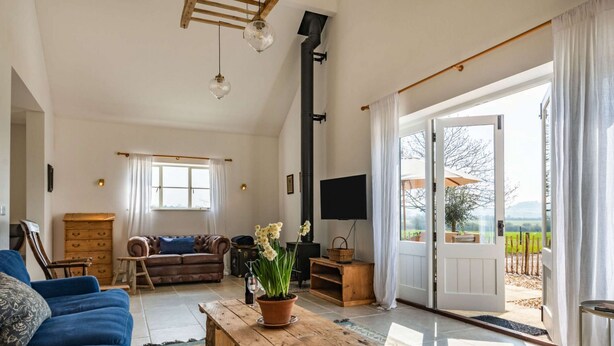 A spacious living room with a sofa, a coffee table, a fireplace, and a television.