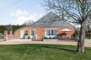 Charming single-story home with a front entrance, porch, and beautifully manicured lawn.