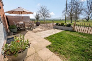 Relax in a serene outdoor space with a stone pathway, seating area, and lush greenery.