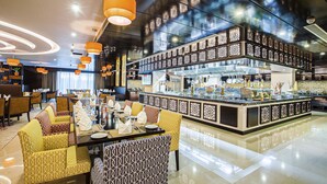 Un restaurant moderne doté d’un bar central, de sièges recouverts d’un tissu à motifs et d’un sol ciré.