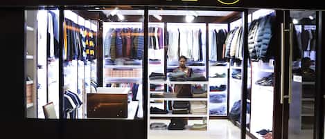 A store named 'URBAN 70' with clothing racks and shelves visible through the glass facade.