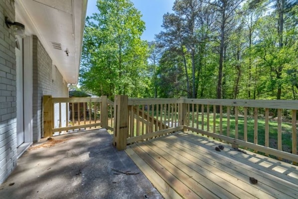 Guests can enjoy an outdoor space with a wooden railing and lush green surroundings.