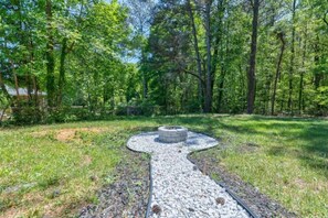 Surrounded by lush trees, this serene outdoor space features a circular structure at its center.