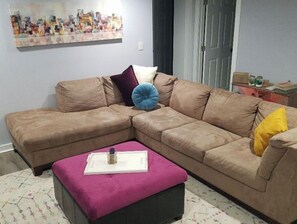 Relax in this stylish living room with a comfortable sofa, ottoman, and geometric-patterned rug.