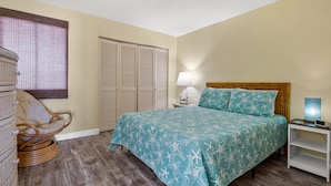 Ein Schlafzimmer mit Bett, Stuhl, Nachttisch und Kleiderschrank.