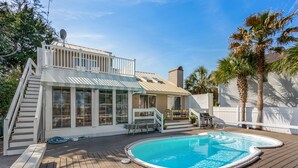 Ein Garten mit Swimmingpool, Holzterrasse und überdachter Veranda.