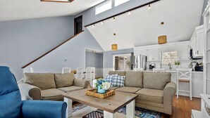 Ein modernes Wohnzimmer mit einer Eckcouch, einem Couchtisch und einem blauen Sessel.