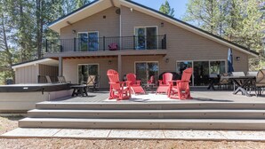 A two-story house with a covered patio area featuring outdoor furniture and a barbecue.