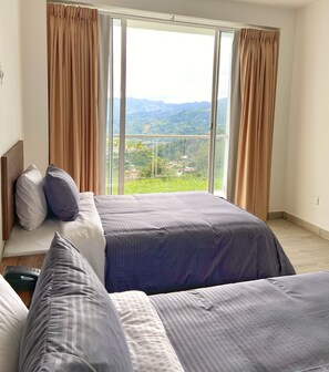 A bedroom with a large window, a bed, and a view of a mountainous landscape. - Hotel Entre Lomas (Dosquebradas)