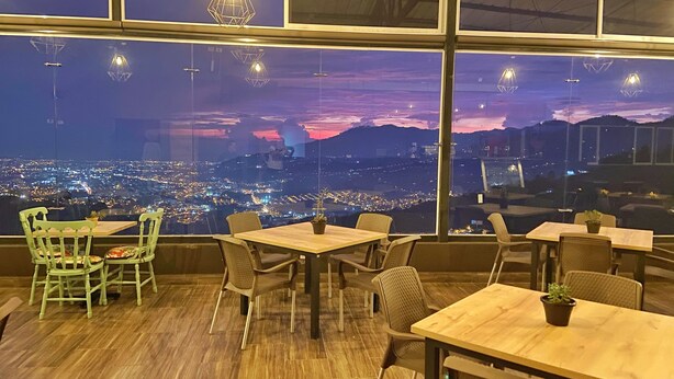 Un restaurante con vistas panorámicas de la ciudad al anochecer.
