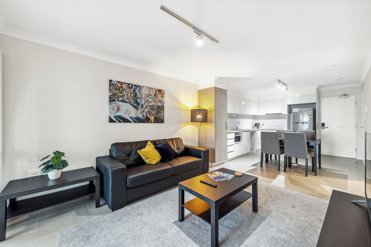 Ein modernes Wohnzimmer mit Sofa, Couchtisch und Kunstwerken.