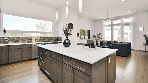 A modern kitchen with a large island, dark wood cabinets, and a stone backsplash. - Private Rooftop - Amazing Skyline Views - Minute Maid Spacious - 3 Bd, 3.5 Ba (Houston)