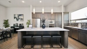 A modern kitchen with a large island, stainless steel appliances, and pendant lighting. - Private Rooftop - Amazing Skyline Views - Minute Maid Spacious - 3 Bd, 3.5 Ba (Houston)