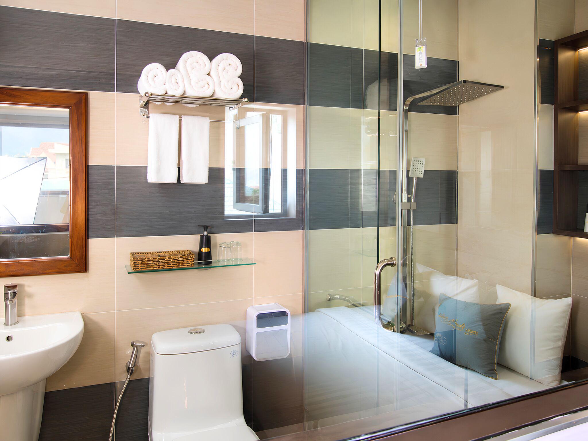 A modern bathroom with a glass shower enclosure, a toilet, a sink, and a mirror.