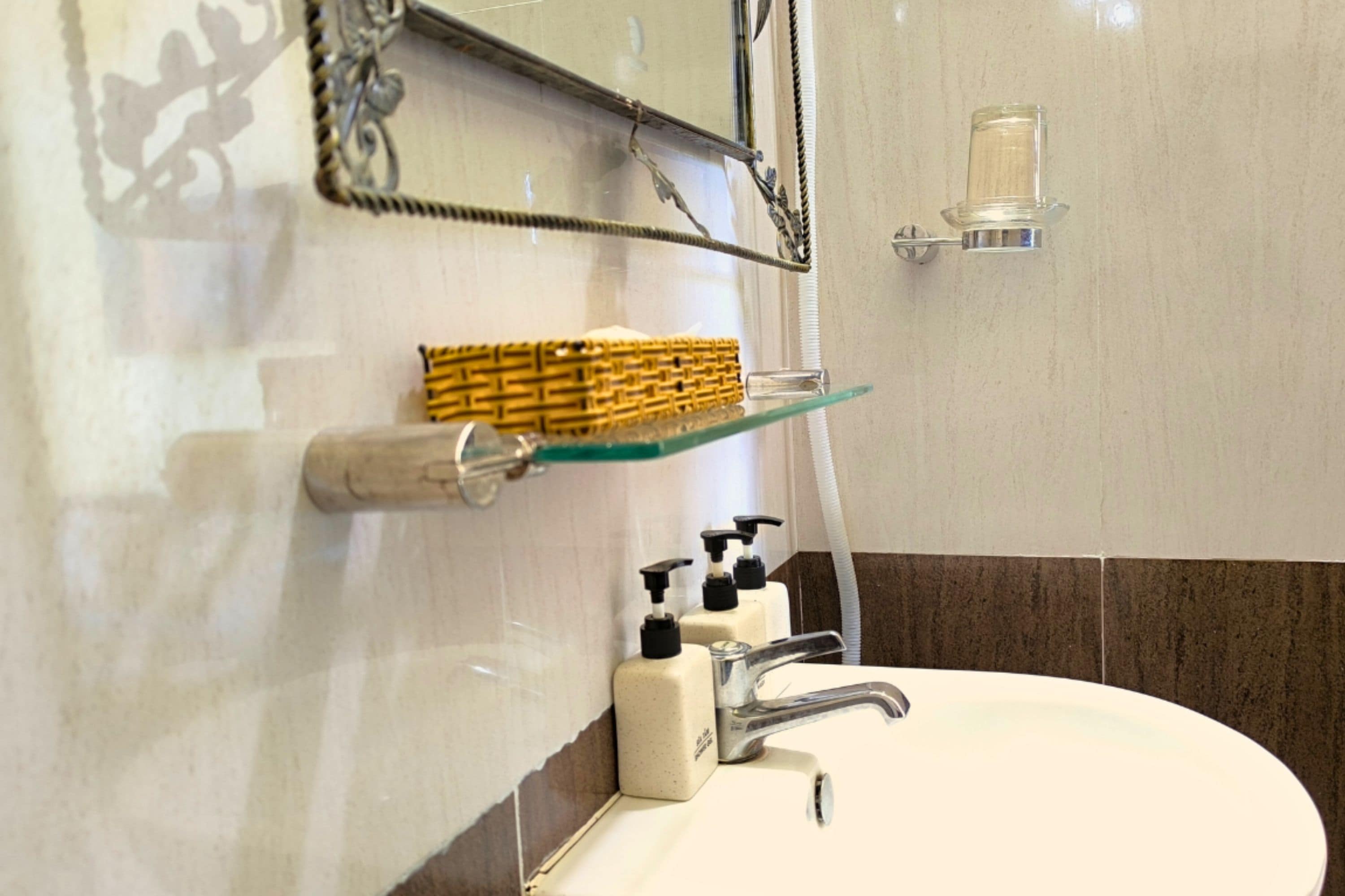 A bathroom with a white sink, a mirror, a towel rack, and a soap dispenser.