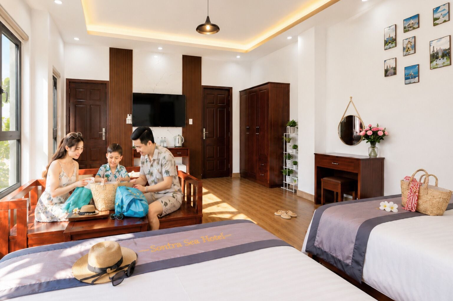 A hotel room with a sofa, a bed, a TV, wooden cabinets, a plant shelf, and artwork on the wall.