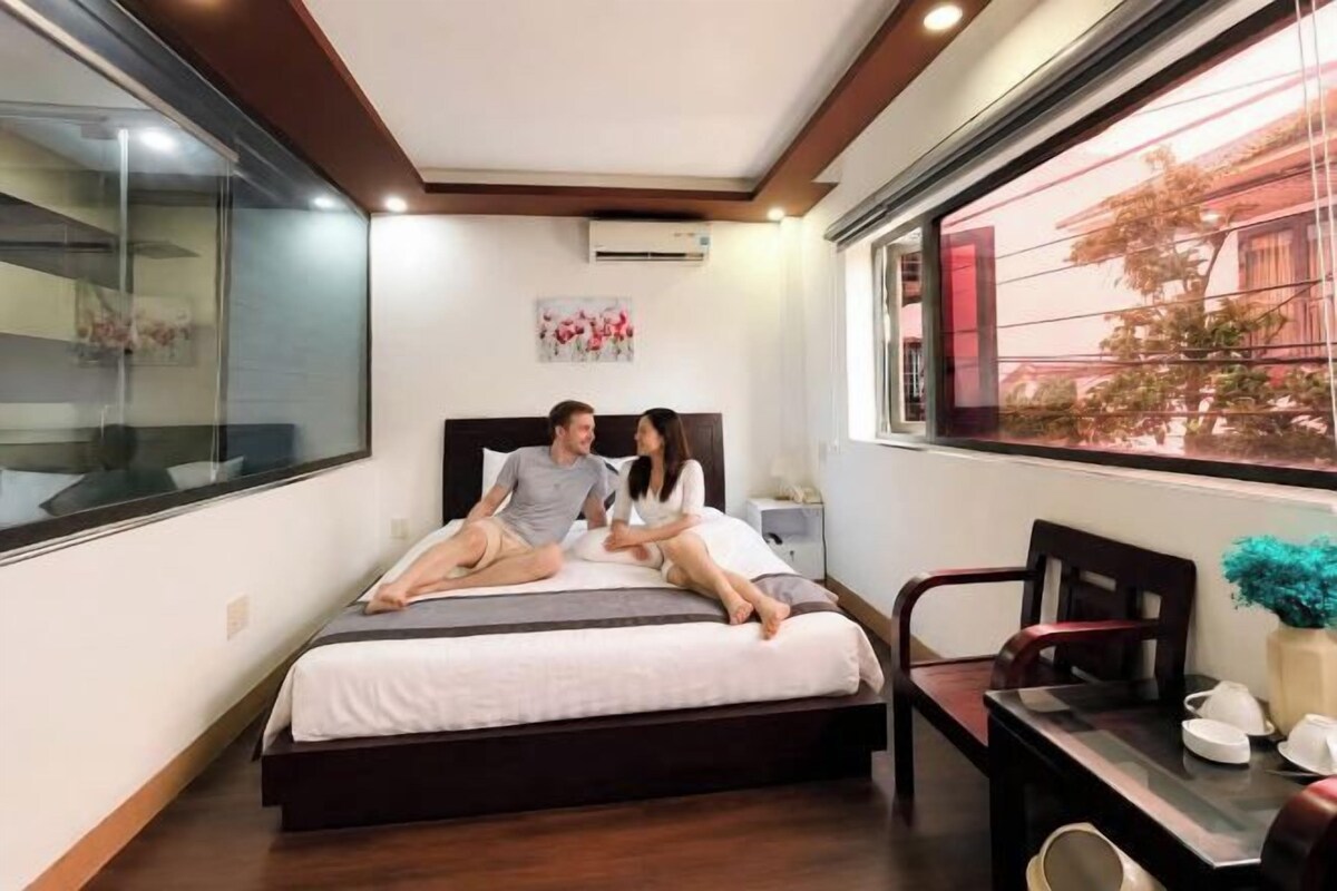 A bedroom with a bed, a desk, and a chair.