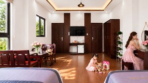 A hotel room with a dining area, a TV, wooden cabinets, and a bed. - SONTRA SEA HOTEL (Da Nang)