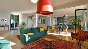 A spacious living area with a green sofa, a coffee table, and a red hanging light fixture.