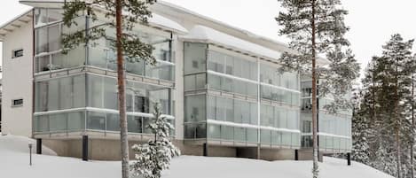 Un bâtiment moderne doté de grandes fenêtres en verre et surplombant un paysage enneigé.