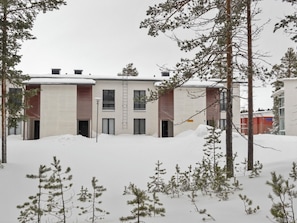 Un bâtiment à deux étages, dont le toit est recouvert de neige, et qui possède un petit porche.