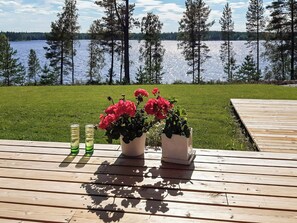 A wooden deck with potted plants and two glasses of a clear liquid. - Paloranta by Interhome (Kuhmo)
