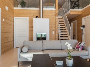 A modern living room with a grey sofa, a coffee table, and a TV.