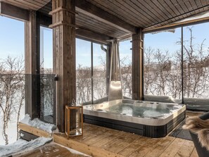 A wooden deck with a hot tub and a glass cabinet. - Haltinmalla by Interhome (Enontekiö)