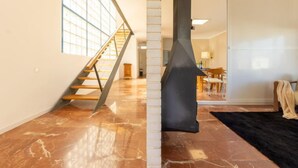 A spacious room with a polished marble floor, a wooden staircase, and a large window providing natural light. - Mar Roig by Interhome (L'Ampolla)